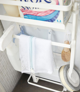 Close up front view of white Magnet Laundry Storage Pockets holding cleaning items by Yamazaki Home. view 6