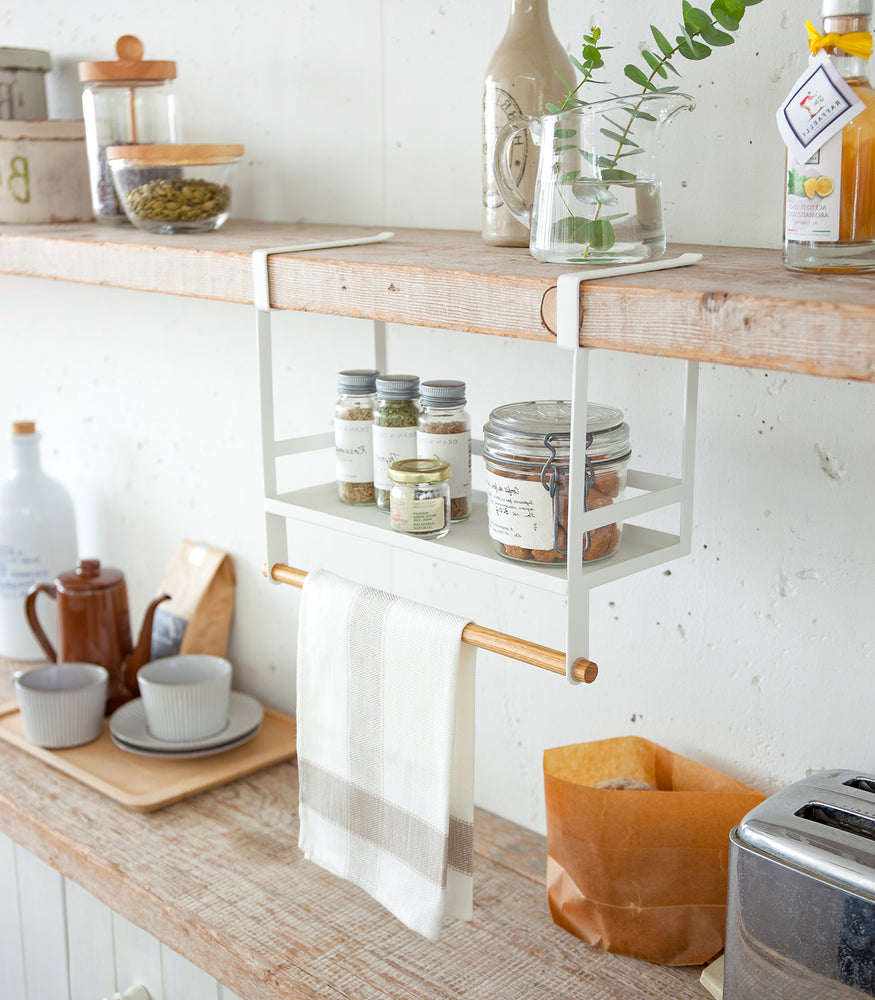 View 3 - White Undershelf Organizer in kitchen holding dish towel and spices by Yamazaki Home.