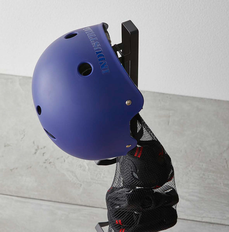 Close up of black Kids' Helmet Stand holding helmet and protective gear by Yamazaki Home.
