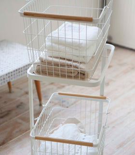 Side view of white Laundry Wagon and Basket holding clothes and towels by Yamazaki Home. view 5