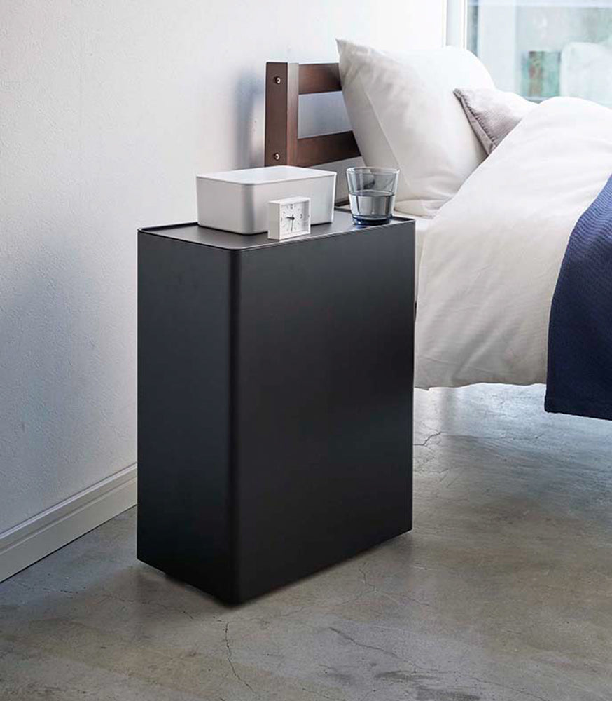 View 9 - Black Rolling Diaper Stacker displaying clock, container, and glass in bedroom by Yamazaki Home.