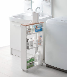 White Rolling Storage Cart holding cleaning supplies in laundry room by Yamazaki Home. view 4