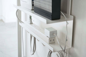Close up view of white Wall-Mount Cable and Router Storage Rack power cord by Yamazaki Home. view 4