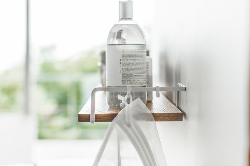 Close up side view of Wall-Mounted Shelf holding cleaning items by Yamazaki Home.