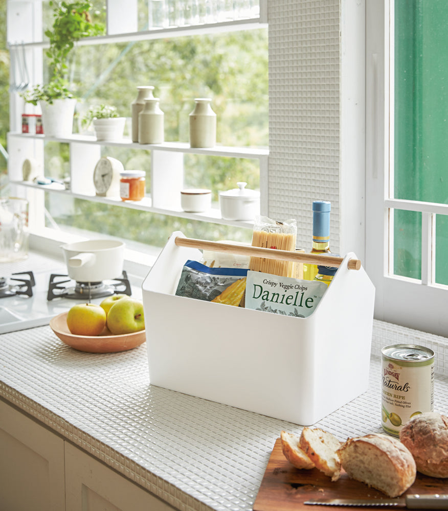 View 3 - White Storage Caddy holding food items on kitchen counter by Yamazaki Home.