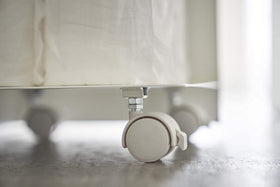 Close up bottom view of white Rolling Bathroom Organizer wheels by Yamazaki Home. view 6