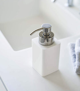 Close up view of white Foaming Soap Dispenser on sink counter by Yamazaki Home. view 4