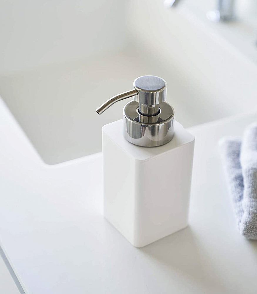 View 4 - Close up view of white Foaming Soap Dispenser on sink counter by Yamazaki Home.