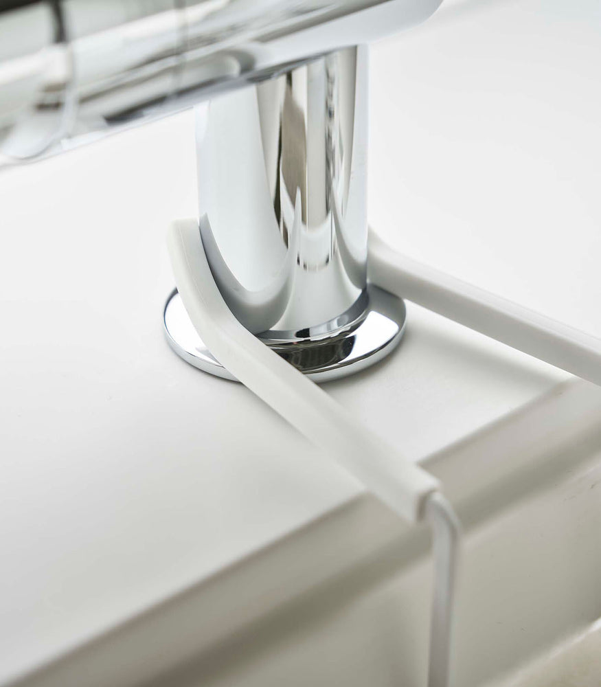 View 7 - Close up of Yamazaki Home white Faucet-Hanging Sponge Caddy attached to a sink