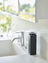 Black One-Handed Push Soap Dispenser on bathroom sink countertop by Yamazaki Home.
