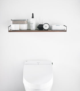 Front view of Wall-Mounted Shelf holding bathroom items in bathroom by Yamazaki Home. view 6