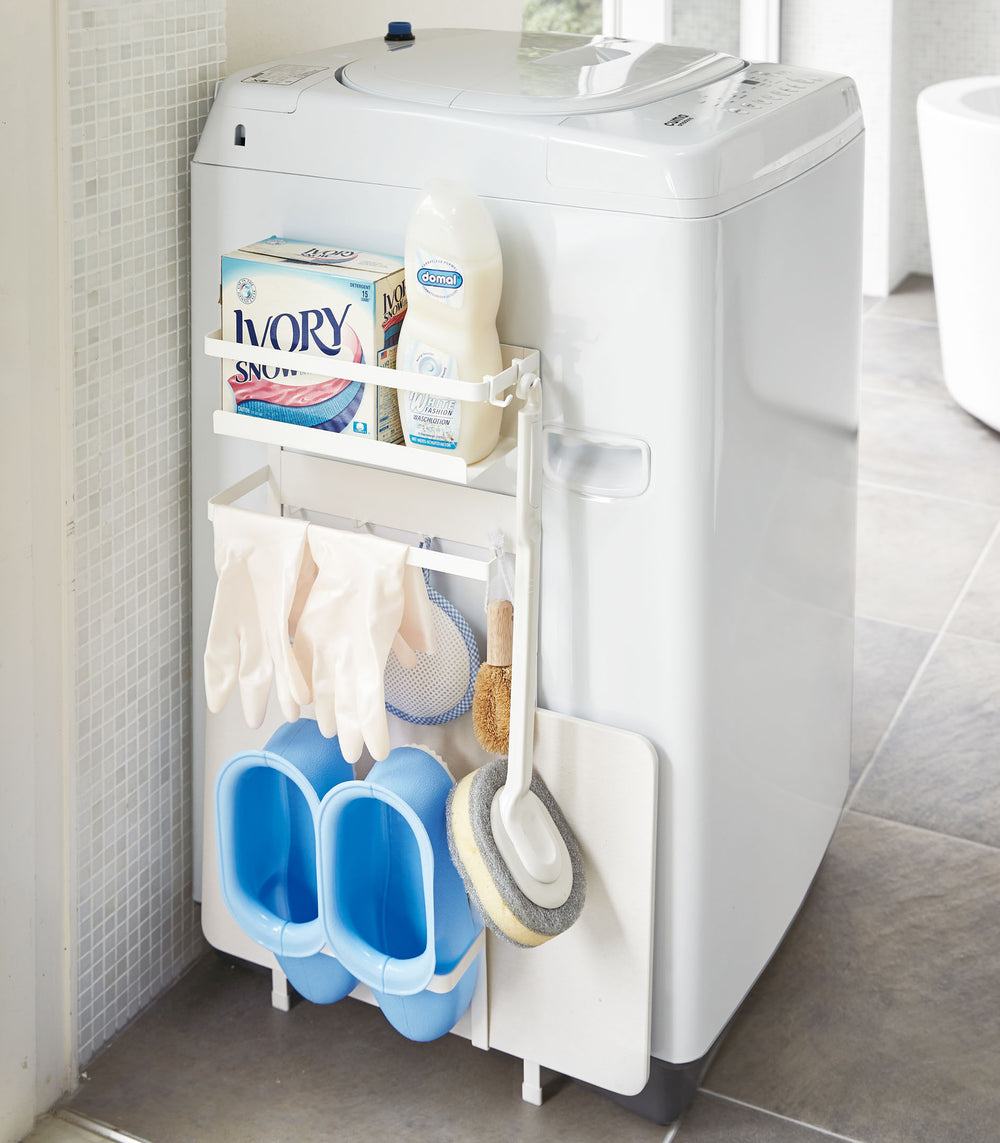 White Magnetic Laundry Storage Pockets holding cleaning supplies in laundry room by Yamazaki Home.