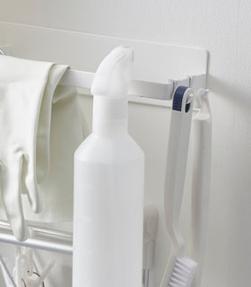 Close up of Magnetic Clothes Hanger Rack holding cleaning items by Yamazaki Home. view 4