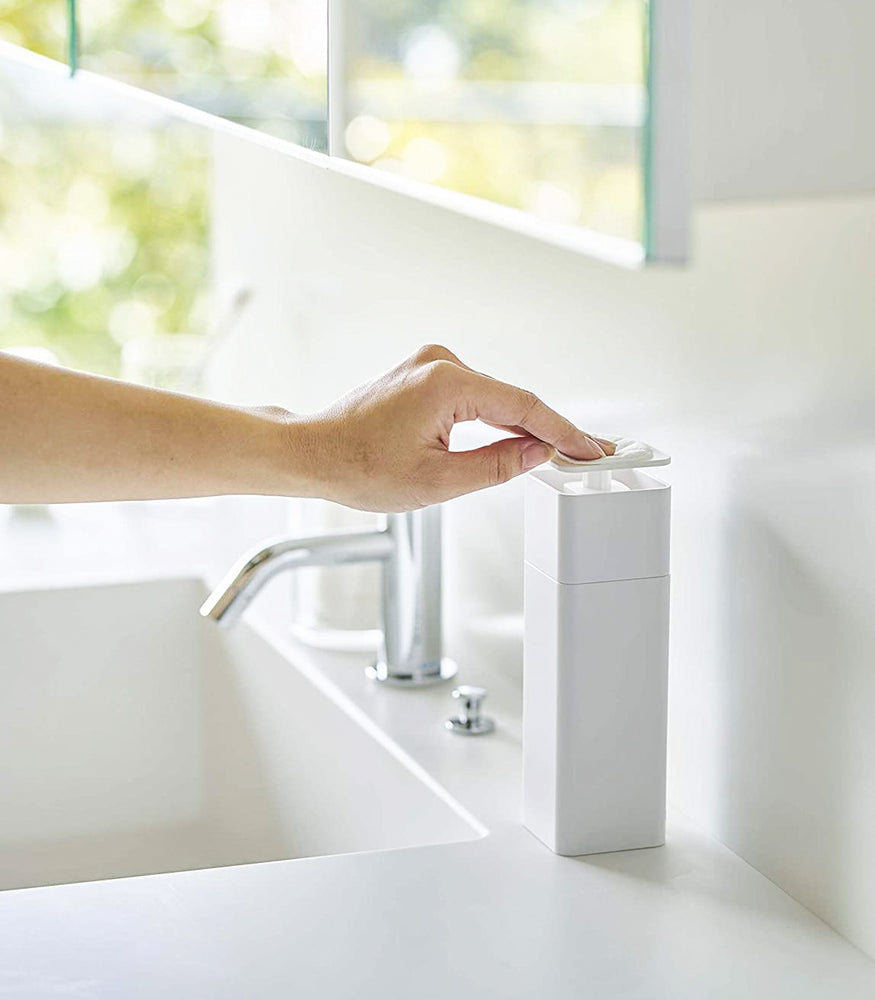 View 4 - White One-Handed Push Soap Dispenser in bathroom sink countertop by Yamazaki Home.