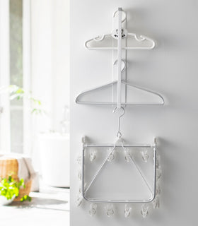 Front view of white Magnet Laundry Hanger Storage Rack displaying hangers by Yamazaki Home. view 4