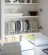 White Dish Storage Rack displaying plates in kitchen cabinet by Yamazaki Home.