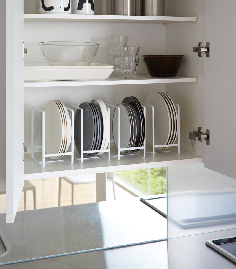 White Dish Storage Rack displaying plates in kitchen cabinet by Yamazaki Home.