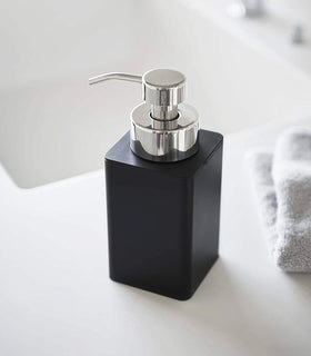 Close up view of black Foaming Soap Dispenser on sink counter by Yamazaki Home. view 9