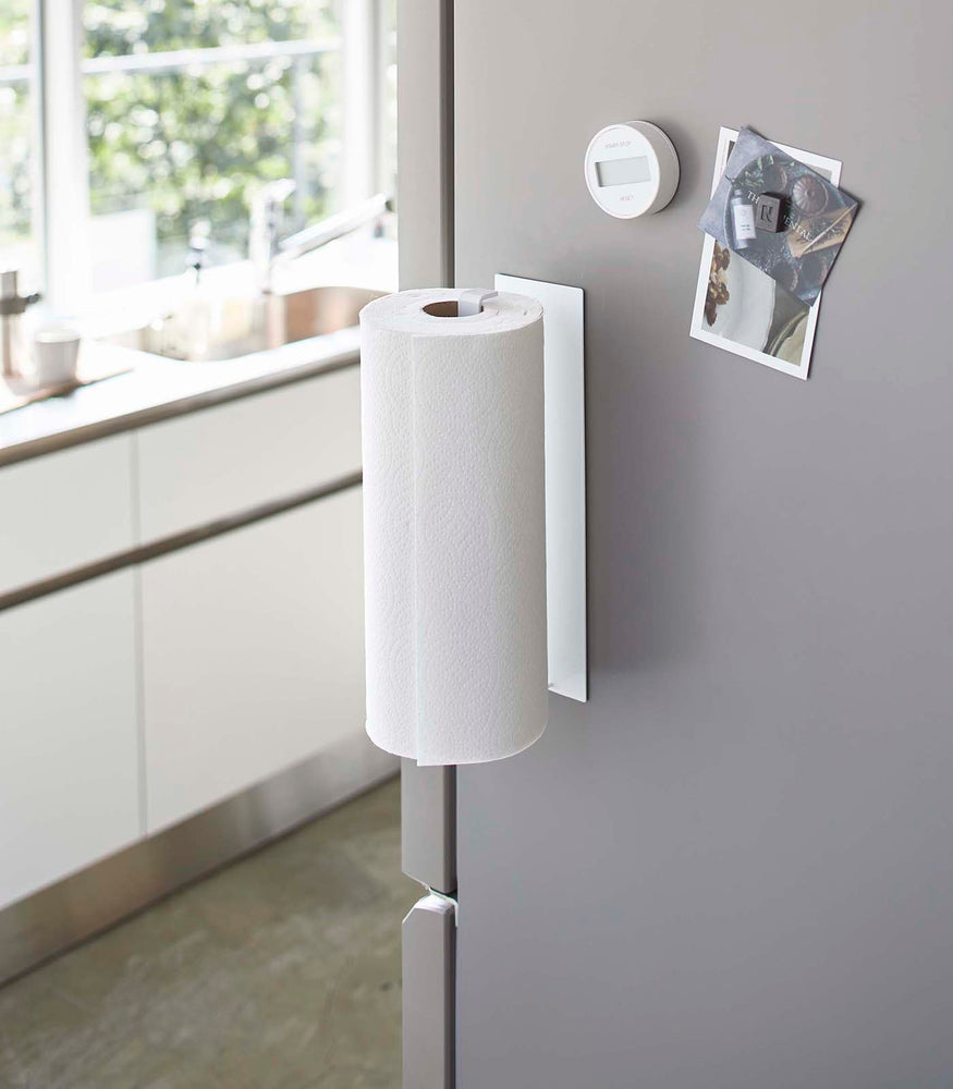 View 3 - Vertical White Magnetic Paper Towel Holder holding paper towels in kitchen by Yamazaki Home.