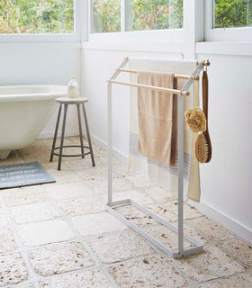 Bath Towel Rack holding towels and brushes in bathroom by Yamazaki Home. view 3