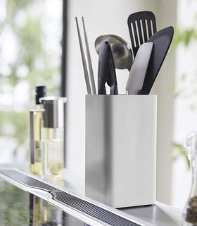 White Utensil Holder holding cooking utensils on kitchen countertop by Yamazaki Home. view 3