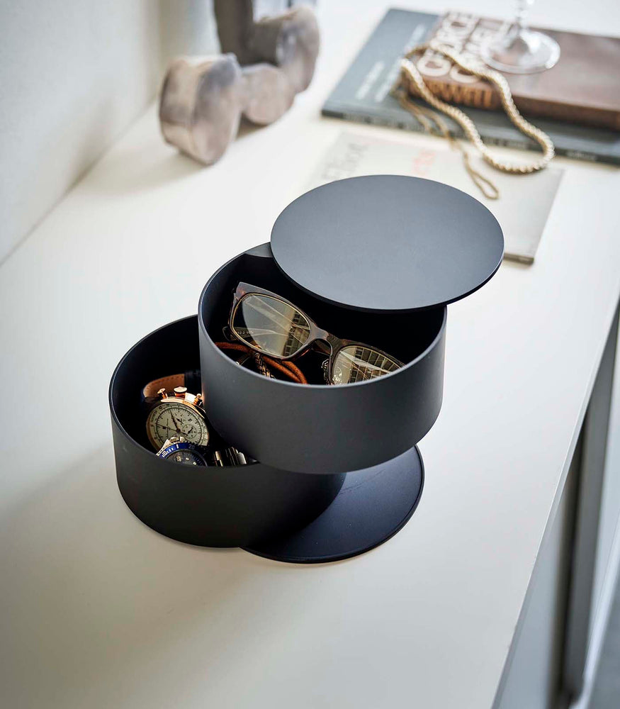 View 10 - Black Stacked Jewelry Box by Yamazaki Home holding glasses, a watch, and other jewelry items.