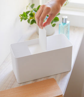 Front view of person inserting divider into white countertop organizer by Yamazaki Home. view 4
