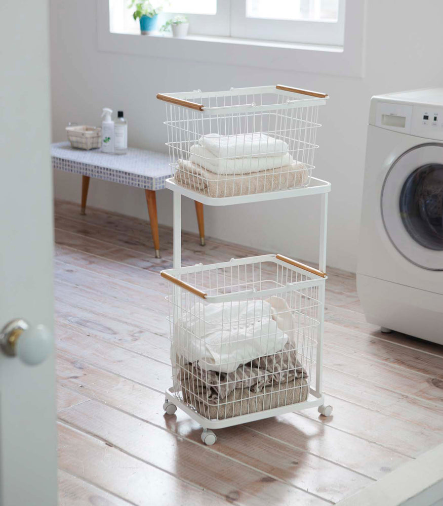 View 2 - White Laundry Wagon and Basket holding clothes in laundry room by Yamazaki Home.
