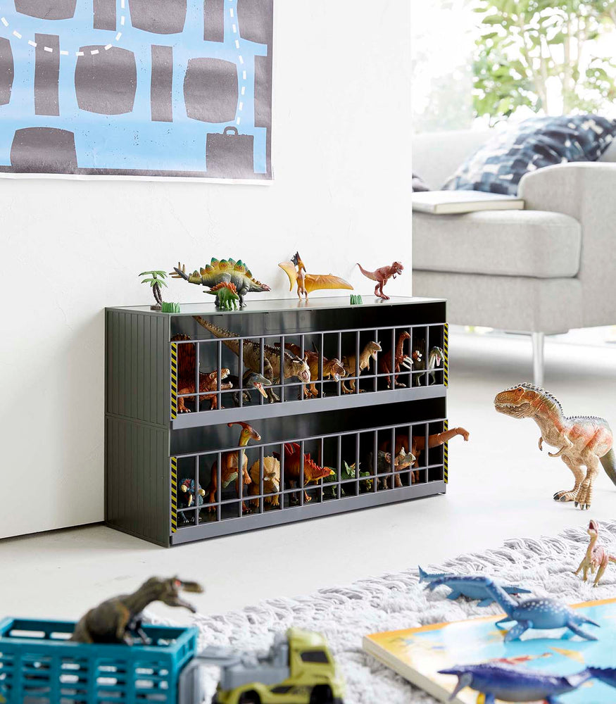 View 12 - Dark Green Two-Tier Toy Dinosaur and Animal Storage Rack in living room play area holding toy dinosaurs by Yamazaki Home.

