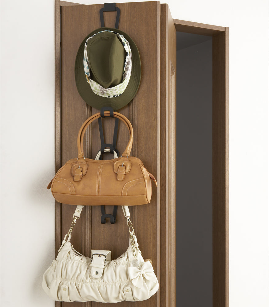 View 8 - Front view of black Chain Link Bag Hanger displaying hat and purses on closet by Yamazaki Home.