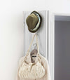 White Over-the-Door Hanger displaying hat, purse, and jacket on door by Yamazaki Home.