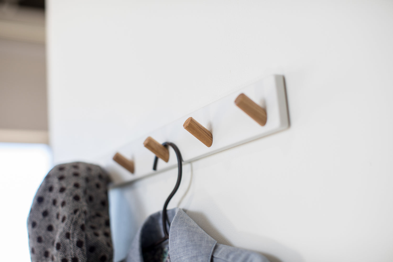 View 5 - White Wall-Mounted Coat Hanger displaying coat and hat by Yamazaki Home.