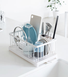 White Dish Rack on kitchen counter holding utensils, plates, and cups by Yamazaki Home. view 3