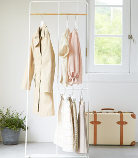Front view of white 2-level Coat Rack holding clothes by Yamazaki Home. view 3