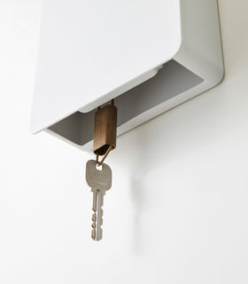 Close up underneath view of white Square Magnetic Key Cabinet holding key by Yamazaki Home. view 6