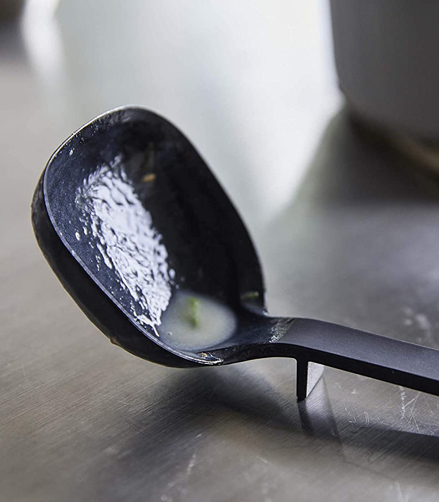 View 5 - Close up view of black Floating Ladle on kitchen counter by Yamazaki Home.