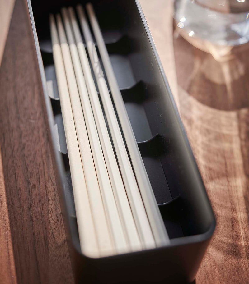 Close up view of black Utensil Case holding chopsticks by Yamazaki Home.