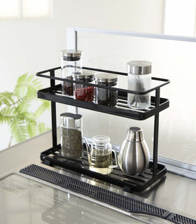 Black Organization Caddy on kitchen stovetop holding spices and oil by Yamazaki Home. view 4