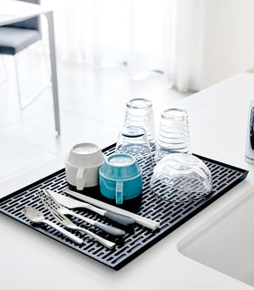 Black Dish Drainer Tray holding dishware on sink countertop by Yamazaki Home. view 7