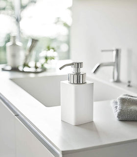 White Foaming Soap Dispenser on bathroom sink countertop by Yamazaki Home. view 2