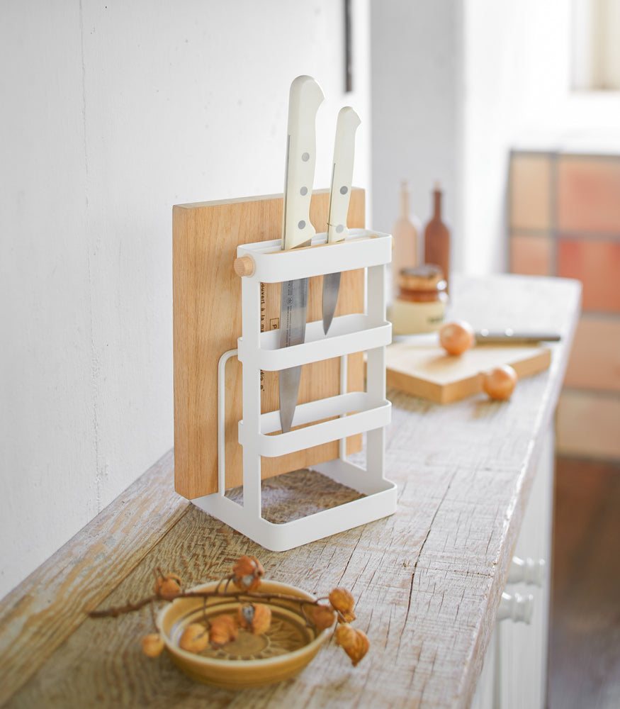 View 3 - White Knife & Cutting Board Stand holding knifes and board on shelf by Yamazaki Home.
