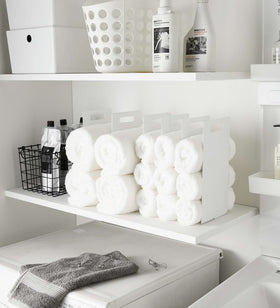White Towel Storage Organizer holding towels in laundry room by Yamazaki Home. view 3