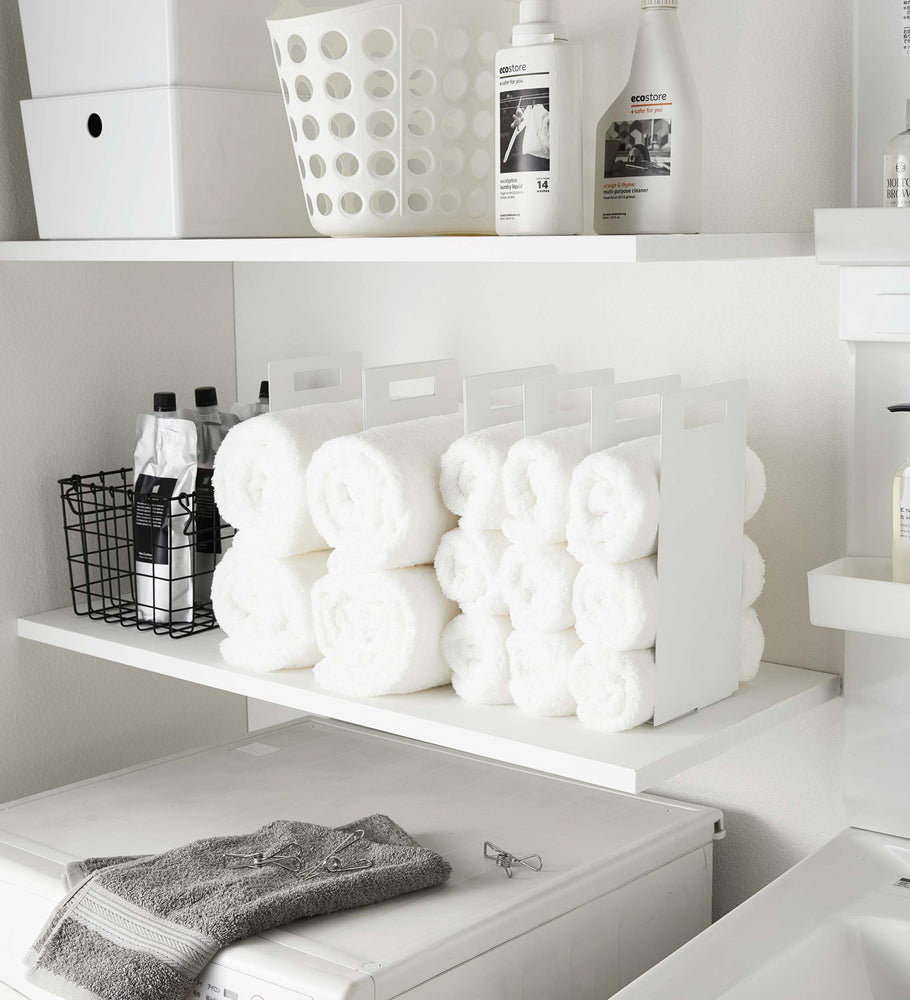 View 3 - White Towel Storage Organizer holding towels in laundry room by Yamazaki Home.