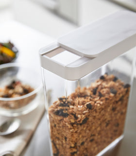 Close up view of white Storage Container holding granola cereal by Yamazaki Home. view 5
