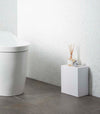 White Wall-Mount Storage on floor in bathroom by Yamazaki Home.