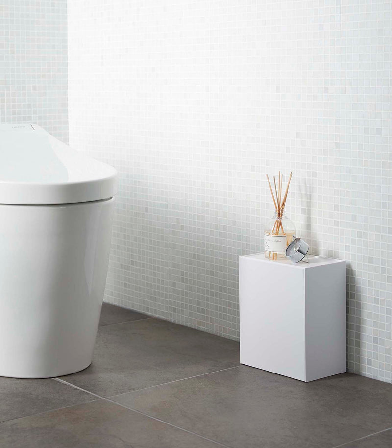 White Wall-Mount Storage on floor in bathroom by Yamazaki Home.