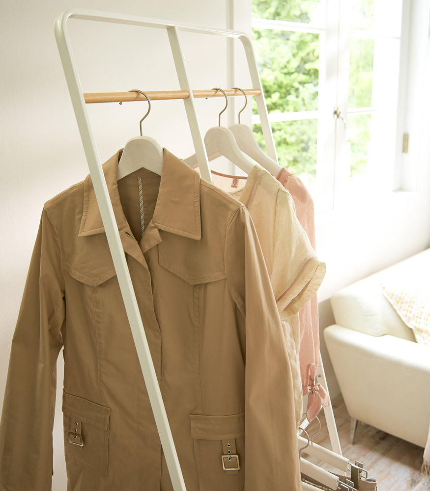View 4 - White 2-level Coat Rack holding clothes by Yamazaki Home.