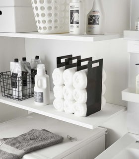 Black Towel Storage Organizer holding towels in laundry room by Yamazaki Home. view 8