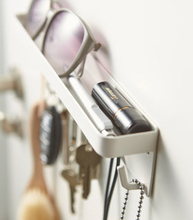 Close up view of white Magnetic Key Rack with Tray holding items by Yamazaki Home. view 5