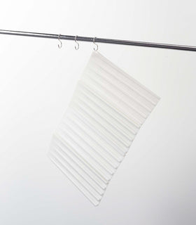 White Folding Dish Drainer Mat hanging on white background by Yamazaki Home. view 5